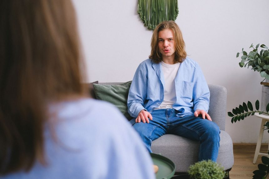 Jovem conversa com uma psicóloga durante uma sessão de psicoterapia em um consultório iluminado.