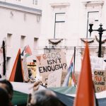 Manifestantes erguem cartazes e bandeiras durante um protesto numa rua de Lisboa.