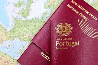 Passaportes português e austríaco sobre um mapa da Europa, representando mobilidade e documentação migratória.